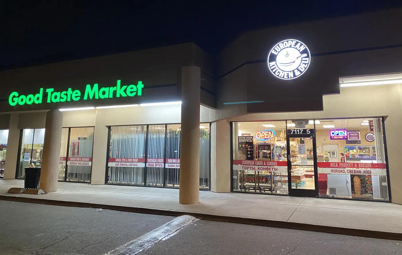 Good Taste Market storefront at night, signs lit